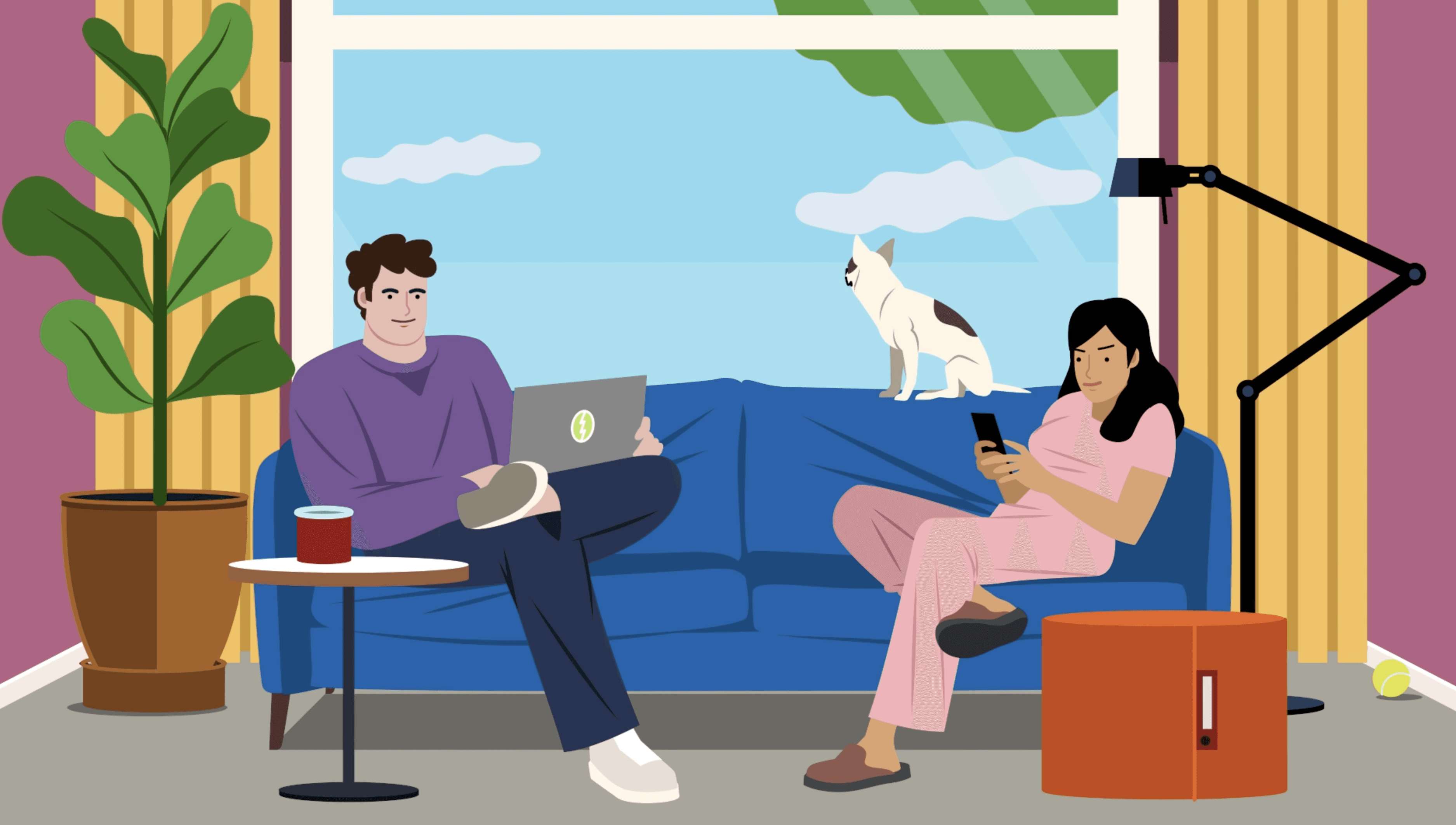 A man and a woman are sitting on a blue sofa with a laptop and a phone. A cat is looking out of the window; there is a plant and a lamp nearby.